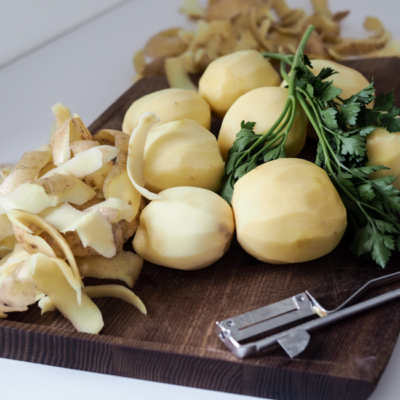 Bio-Erdäpfel geschält auf einem Schneidebrett.