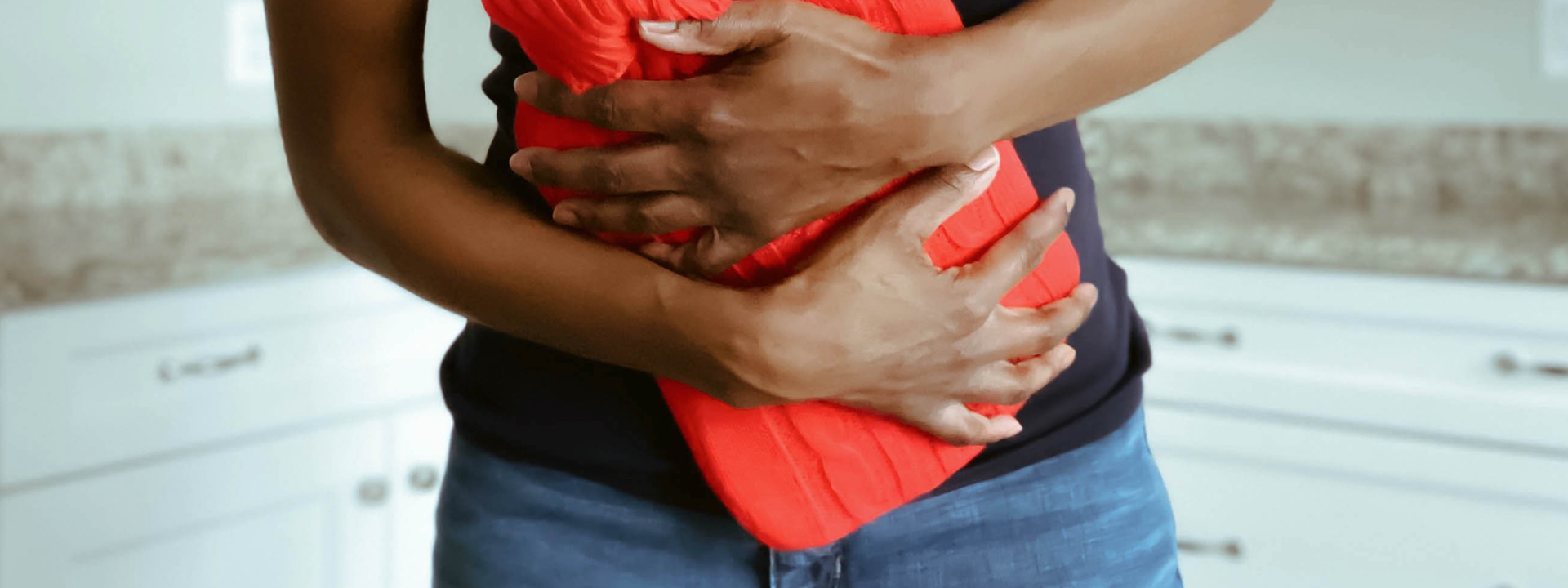 Frau mit Wärmflasche auf dem Bauch, Magazinbeitrag von Ja! Natürlich