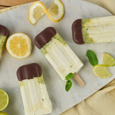 Fertiges Bio-Eis auf einem Steinbrett mit Zitronen und Minze dekoriert.