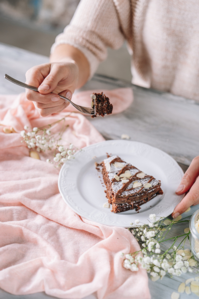 Jemand nimmt eine Gabel voll Bio-Schokokuchen.