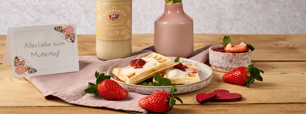 Waffeln auf einem Teller mit Erdbeeren und einer Karte zum Muttertag
