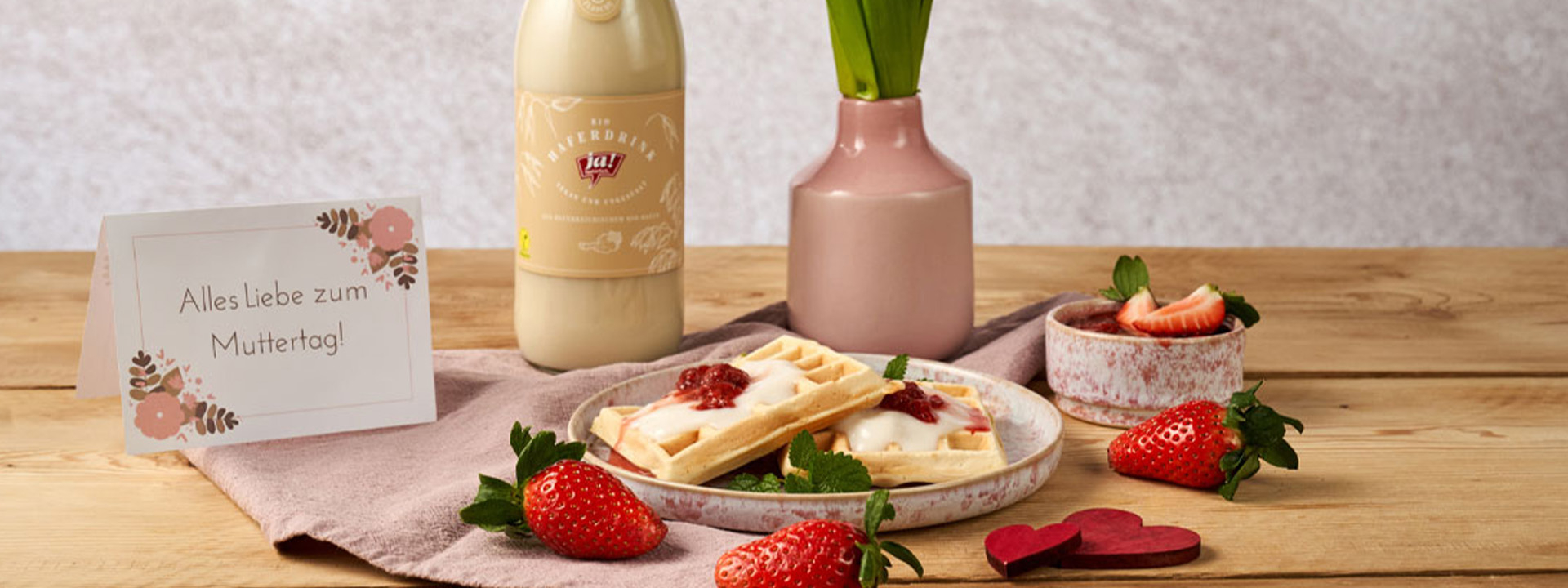 Waffeln auf einem Teller mit Erdbeeren und einer Karte zum Muttertag