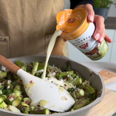 Schlagobers wird zu den anderen Zutaten in eine Pfanne gegossen.