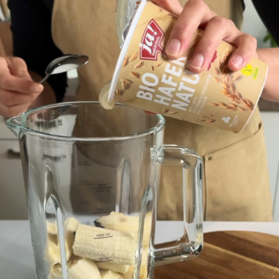 Bio-Banane und Hafer Natur Joghurt werden in einen Mixer gegeben.