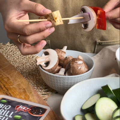 Bio-Grilltofu und Bio-Gemüse wird auf einen Spieß gesteckt