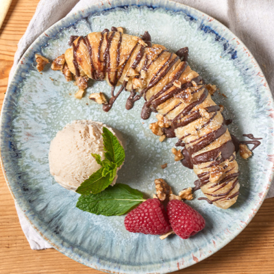 Bio-Grillbananen auf einem Teller mit Bio-Eis und Beeren angerichtet