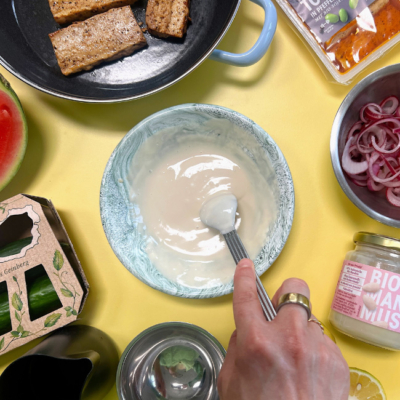 Bio-Dip in einer Schale drum Herum Tofu in einer Pfanne und kleingeschnittenes Gemüse in einer Schale