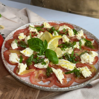 aradeiser Carpaccio auf einem Teller angerichtet und mit Mozzarella getoppt