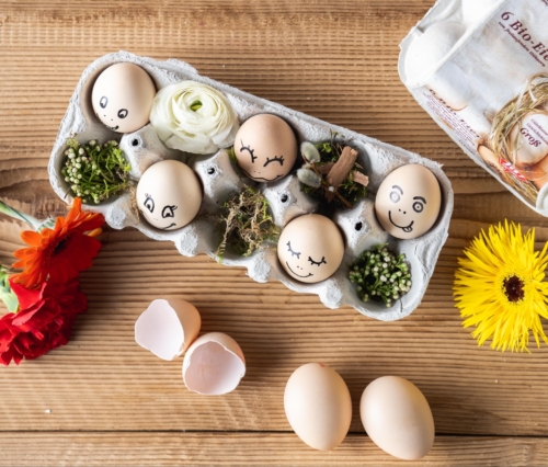 Bio-Eier mit Gesichtern im Eierkarton.