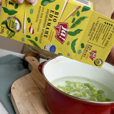 Bio-Edamame werden in heißes Wasser gegeben