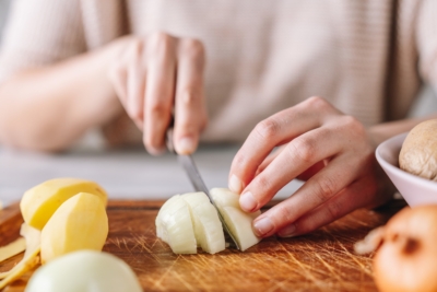 Jemand schneidet Bio-Zwiebel.