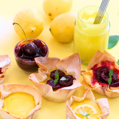 Fertige Lemon Cherry Cups und frische Zitronen liegen auf einem Tisch