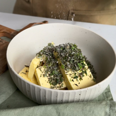 Bio-Kräuter werden mit Bio-Butter vermengt.