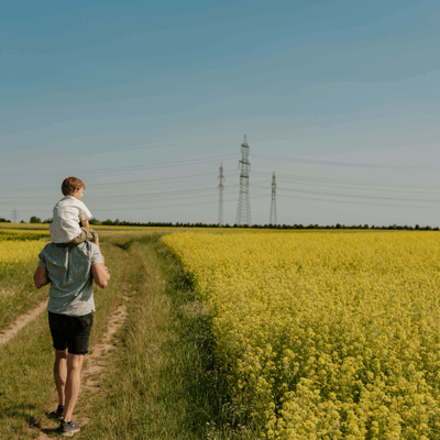 Franz Schwarz-Maad trägt seinen Sohn auf den Schultern am Feld