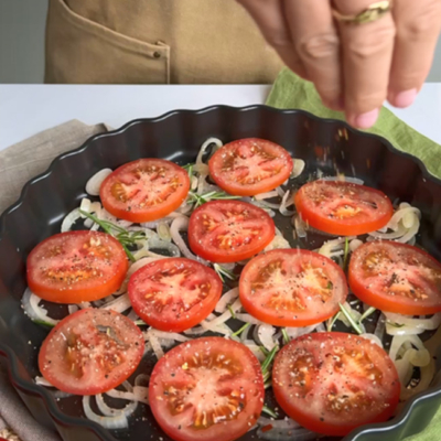 Tomaten werden in einer Tarte-Form gewürzt