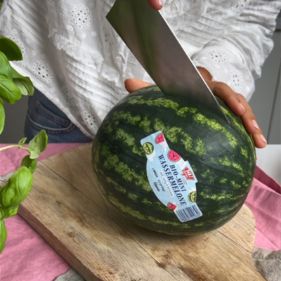 Bio-Melone wird mit einem Messer durchgeschnitten