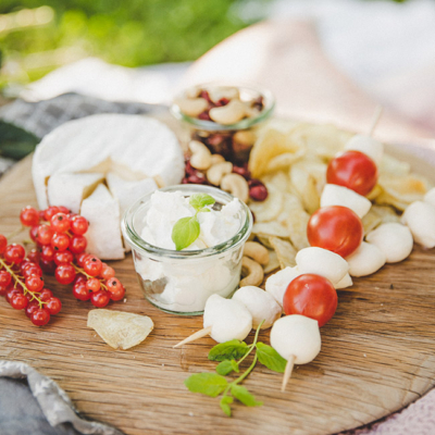 Eine Bio-Käseplatte mit Paradeisern, Ribiseln und Nüssen.