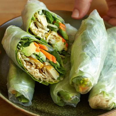 Bio-Gemüse-Frühlingsrollen mit Tofu, Karotten und Blattsalat auf einem Teller.