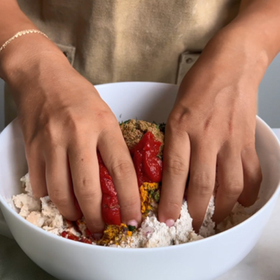 Gewürze werden zu Tofu gegeben und mit den Händen vermengt