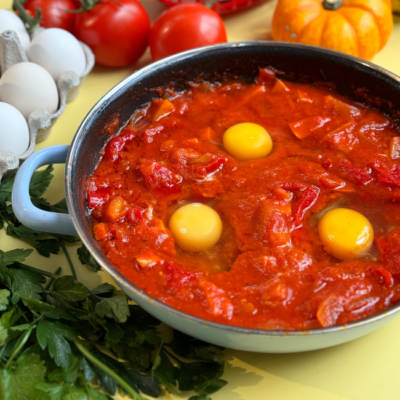 Bio-Eier werden in das Shakshuka gegeben