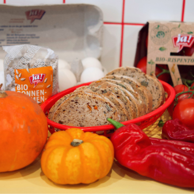 Bio-Kürbis, Bio-Paprika, Bio-Brot und Bio-Sonnenblumenkerne auf einem Tisch