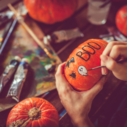 Kürbisse werden mit Farbe und Pinsel bemalt