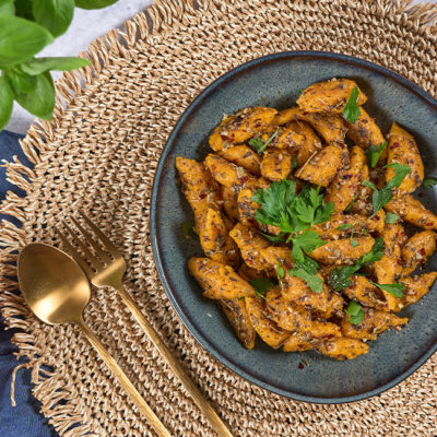 Fertige Kürbis-Scherennudeln auf einem Teller mit frischen Kräutern angerichtet