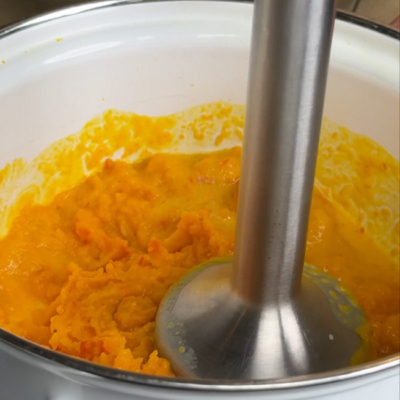 Bio-Kürbis wird mit einem Stab püriert