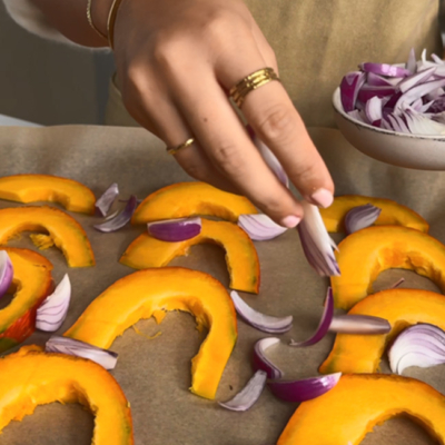 Bio-Kürbis und Bio-Zwiebel auf ein Blech geben und im Ofen backen