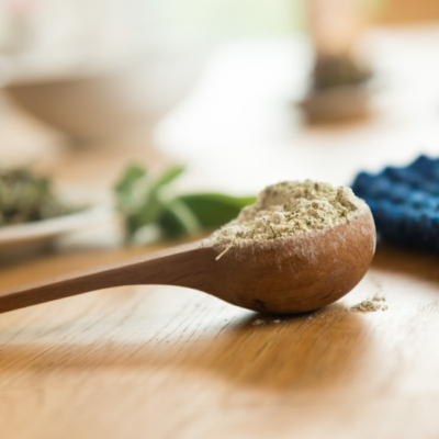 Holzlöffel mit Fußpuder darauf liegt auf Holztisch