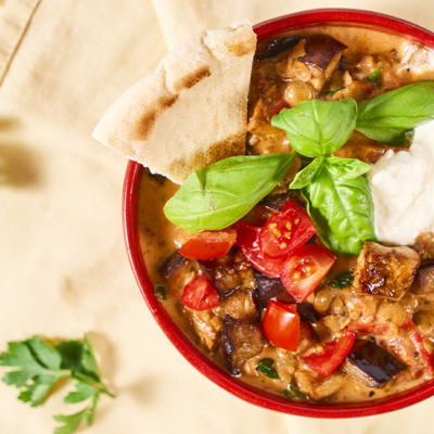 Geröstete Melanzani in einer Schale mit Linsen und Kräutern