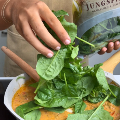 Frischer Bio-Spinat wird dem Eintopf hinzugefügt