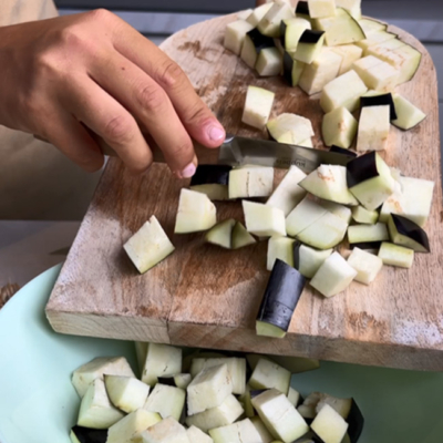 Melanzani kleingeschnitten werden in eine Pfanne gegeben