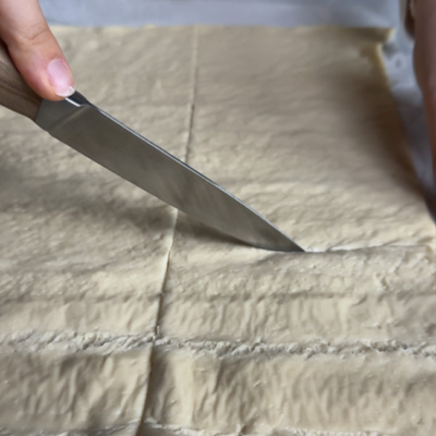 Pizzateig in Rechtecke schneiden