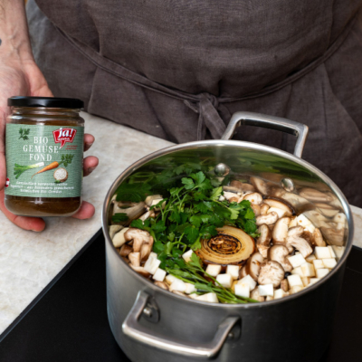 Pilzsuppe wird mit Gemüsefond aufgegossen