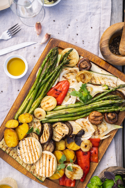 Gegrilltes Bio-Gemüse auf einem Schneidebrett.