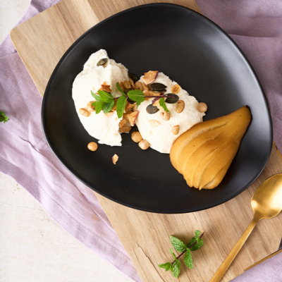 Bio-Winterzeit Joghurt Mousse mit eingelegter Birne angerichtet auf einem Teller