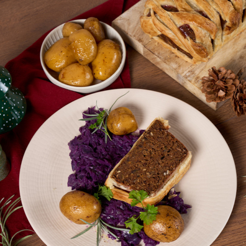 Veganer Braten auf einem Teller angerichtete mit Erdäpfel und Rotkraut