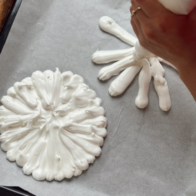 Baiser-Masse wird mit einem Spritzbeutel auf ein Blech gespritzt