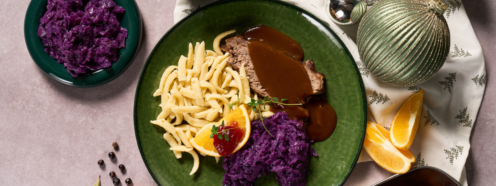Sauerbraten mit Rotkraut und Nockerl angerichtete auf einem Teller