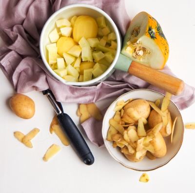 Geschälte und geschnittene Bio-Erdäpfel und Kürbis in zwei Schüsseln.