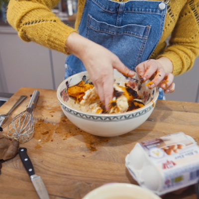 Jemand vermengt Zutaten in einer Schüssel, daneben steht eine Packung Ja! Natürlich Bio-Eier.