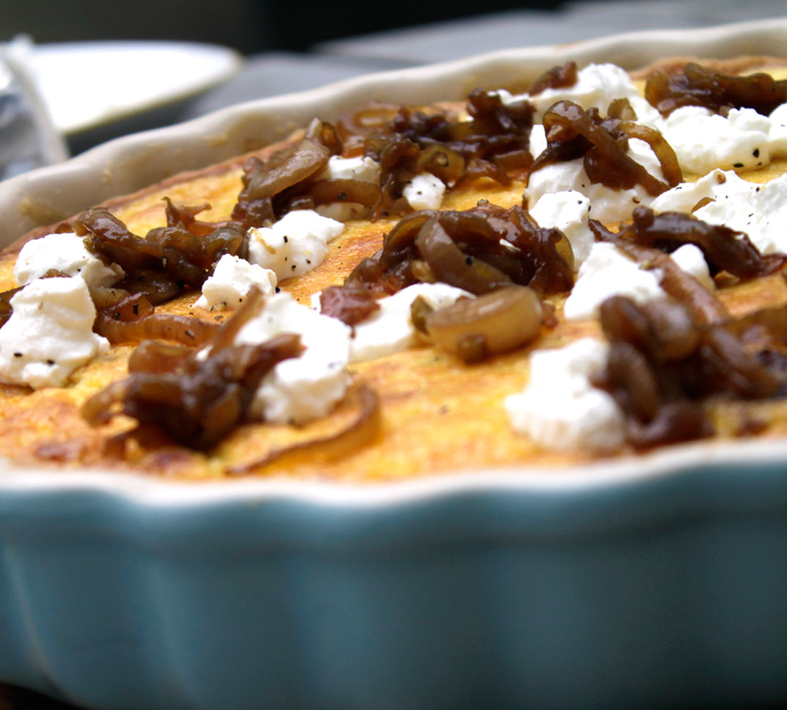 Nahaufnahme einer Quiche mit karamellisierten Bio-Schalotten und Ziegenfrischkäse.
