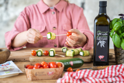 Jemand bereitet Grillspieße mit Bio-Gemüse von Ja! Natürlich vor.
