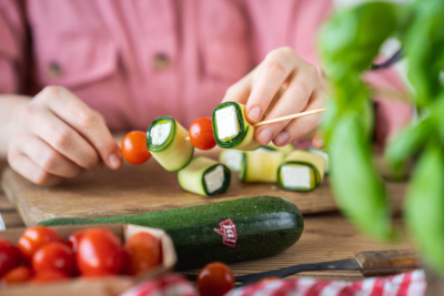 Jemand bereitet Grillspieße mit Bio-Gemüse von Ja! Natürlich vor.
