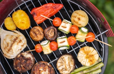 Bio-Grillgemüse auf Spießen mit Zwiebeln, Champignons und Paprika am Grill.