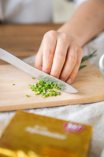 Jemand schneidet Bio-Schnittlauch.
