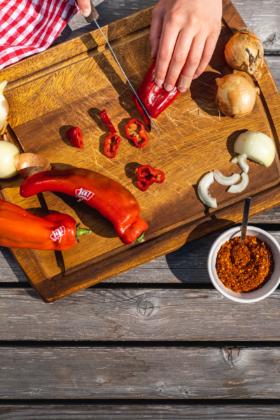 Jemand schneidet Bio-Spitzpaprika.