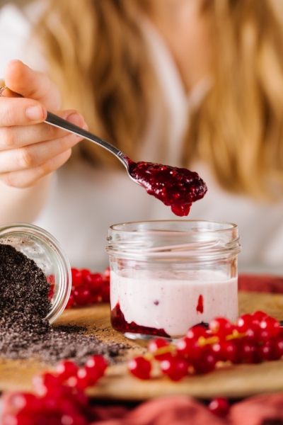 Jemand nimmt einen Löffel Bio-Preiselbeermarmelade.