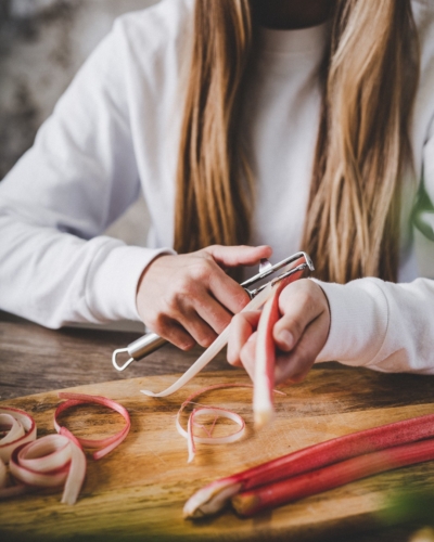 Jemand schält Bio-Rhabarber.